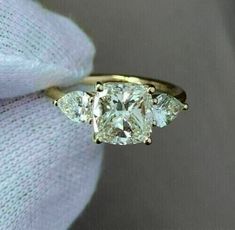 three stone diamond ring on white cloth