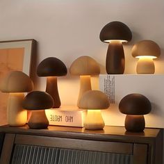 several mushrooms are lit up on the shelf next to a wall mounted book and lamp