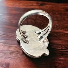 a silver ring sitting on top of a wooden table