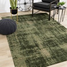 a living room area with a green rug, chair and clock on the wall behind it