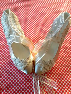 two pairs of wedding shoes sitting on top of a red and white checkered tablecloth