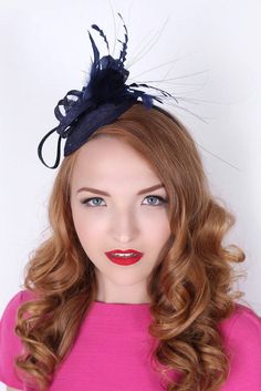 "\"Arianna\" Navy Blue Fascinator This season, sophisticated fascinators stole the show on the runways. Fascinators can be a little intimidating. But this cute little fascinator will help you overcome that fear. It perfectly lands the look, thanks to its mesh sinamay, frilly feathers, and loopy mesh ribbons. No matter the occasion, you will fit in with the fascinator craze with this simple yet stylish head-piece. Add Men's Matching Bow Tie: Don't you dare get caught mismatching your sweetie's fa Fitted Evening Hair Accessories For Kentucky Derby, Elegant Fascinator For Royal Ascot Costume Party, Elegant Fascinator For Costume Party At Royal Ascot, Elegant Headpieces For Kentucky Derby Costume Party, Elegant Mini Hats For Kentucky Derby Costume Party, Elegant Headband Fascinator For Costume Party, Elegant Mini Hat Headband For Costume Party, Elegant Mini Hat With Headband For Costume Party, Chic Blue Fascinator For Races