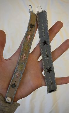 two handmade bracelets are held in the palm