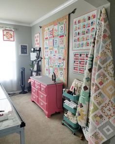 a room filled with lots of quilts on the wall