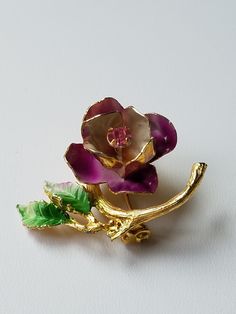 "These lovely vintage Rose Brooch is made in Austria. The Rose is 3 dimensional and has open petals in a purplish pink color enamel with a long bud at the center in a Pink Austrian Crystal. The finish is in a brushed gold enamel branch with 2 Green enamel leaves. The brooch is very well constructed with no enamel wear and is absolutely gorgeous. Any Mother would love this brooch, so before looking else where shop here first. The brooch will come gift box with FREE SHIPPING. Measure: 1 1/2\"L X 1 Vintage Rose Brooch For Gift, Vintage Rose Brooches For Gifts, Vintage Rose Brooches As Gift, Pink Flower Enamel Brooch, Vintage Pink Enamel Brooch Pin, Vintage Pink Enamel Pin Brooch, Vintage Pink Enamel Pin Gift, Vintage Pink Enamel Brooches, Vintage Rose Flower Brooch