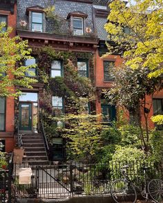 an apartment building with many windows and plants growing on it