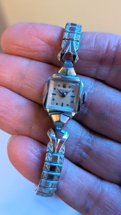 "This is a beautiful Benrus ladies watch that is currently working! I am not a watch expert, nor have I had it tested or serviced, it is being sold AS IS. I've wound it several times and it keeps fairly good time, not perfect, but ok.  I would strongly recommend having it serviced by a professional. The square face has a pearly white face with silver hands and numerals. The watch screams DECO! This watch is approximately 6.5\" with an etched stretch band. The watch is marked 10k RGP.  Given the age of the watches there will be scuffs and scratches, I do my best to highlight them in the pics and detail them in the description so there are no unpleasant surprises after purchase! This one is really lovely!! This bracelet makes a statement and are perfect for anyone who loves vintage or steamp Square Face, Stretch Band, Square Faces, Stretch Bands, White Face, Women Wrist Watch, Steampunk Fashion, Ladies Watch, Jewelry Cleaner