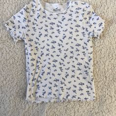 This Shirt Is Super Cute And Never Worn No Flaws Barely Cropped Smoke Free Home This Shirt Is Perfect For Springtime And Summer To Style With Leggings Or Jeans! Casual Cotton Patterned Tops, Cute Patterned Cotton Tops, Cute Cotton Tops With Pattern, Cute Cotton Patterned Tops, Patterned Short Sleeve Cotton Tops, Patterned Cotton Short Sleeve Tops, Cute Printed Blue Tops, Patterned Cotton Crew Neck Top, Casual White Tops With Floral Print