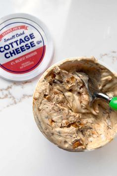 an ice cream in a cup next to a container of cottage cheese