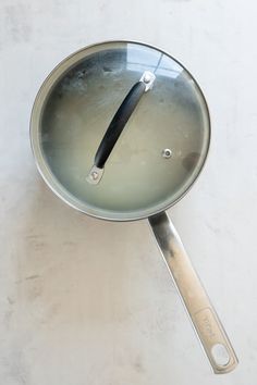 a frying pan filled with liquid on top of a white counter