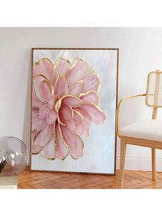 a large pink flower sitting on top of a white wall next to a chair and table