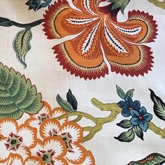 an orange and green floral design on white fabric