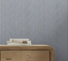 an old fashioned radio sitting on top of a wooden table next to a blue striped wall