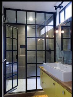 a bathroom with a sink, mirror and shower stall in the corner next to it