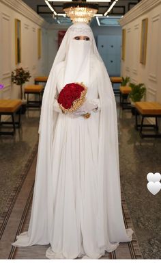 a woman dressed in white holding a bouquet of flowers