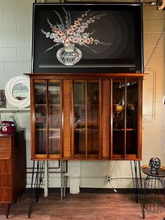 an old fashioned display cabinet with flowers on it