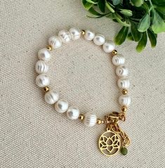 The combination of simplicity and sophistication makes this bracelet an elegant jewel of natural beauty. The lotus flower charm represents the path to spiritual renewal and enlightenment and the pearls inspire purity and peace. Freshwater pearls and 18k gold over steel accessories. Adjustable from 5.5" to 7.5" All jewelry is handmade to order in our Port Richey, Fl studio by owner and designer, Soledad. Please allow me 1-3 business days to make and package your piece(s). Your items are expected Spiritual Pearl Bracelet, Spiritual Beaded Bracelets With Pearl Charm, Spiritual Pearl Bracelet With Pearl Charm, Spiritual Pearl Bracelet With Charm, Spiritual Pearl Bracelet With 8mm Beads, Spiritual 8mm Pearl Beads Bracelet, Spiritual Pearl Bracelet With Pearl Charm As Gift, Spiritual Pearl Bracelet With Charm As Gift, Spiritual Pearl Charm Bracelet As Gift