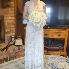 a woman standing in front of a tv holding a bouquet of flowers