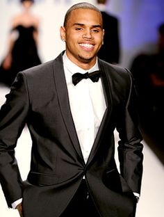 a man in a tuxedo and bow tie on the catwalk at a fashion show