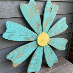 a painted wooden flower on the side of a house