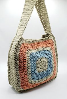 a crocheted handbag is shown on a white background with a blue and orange square