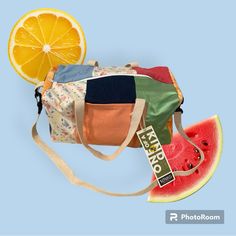 a watermelon, orange and other fruits are on the blue background with a tote bag