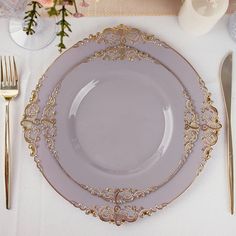 a table setting with silverware and gold place settings for two people to sit at