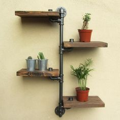 three wooden shelves with plants and pots on them