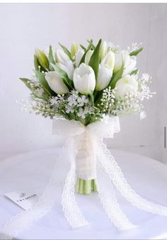 a bouquet of white tulips and baby's breath