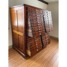 an old wooden filing cabinet sitting on top of a hard wood floor