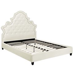 a white bed with an ornate headboard and foot board