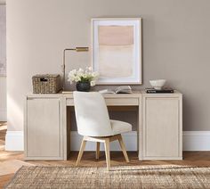 a white chair sitting next to a desk on top of a hard wood floor in front of a painting