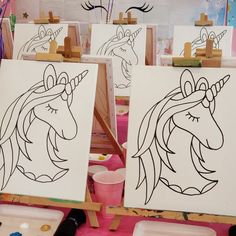 two unicorns are shown on easels in front of some paint and canvases