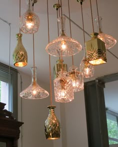 a chandelier with wine glasses hanging from it's sides and lights in the middle