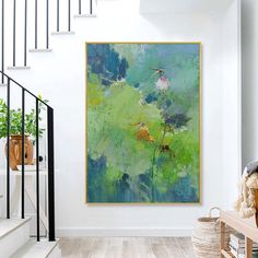 a painting hanging on the wall next to a stair case in a room with white walls