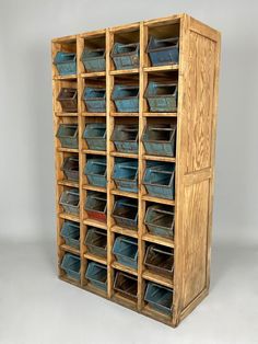 a large wooden storage unit filled with lots of blue bins on top of it