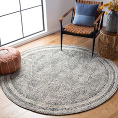 a round rug in the middle of a living room with a chair and vases