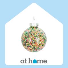 a glass ornament filled with sprinkles on top of a blue background