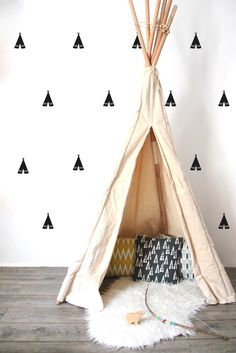 a teepee is in front of a wall with black triangles on it