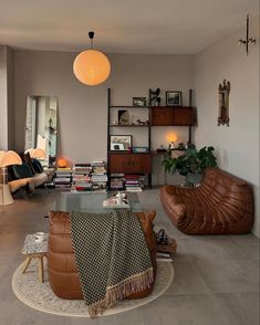 a living room filled with lots of furniture and bookshelves next to a window