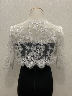 White floral lace wedding handmade bolero. Bridal and evening lace long sleeves jacket. Scalloped edgings and sleeves shrug. Corded Sequined Lace Bolero.    This elegant handmade design has a pretty scalloped lace edge all the way around and on the long-length sleeves as well. A small hook closure finishes it off at the neckline to allow movement and to show your dress or top underneath. The hand-made pearl brooch covering the hook closure gives a more luxurious and stylish look.  Sizes  S - M Elegant Long Sleeve Dress For Mother Of The Bride, Fitted Long Sleeve Lace Mother Of The Bride Dress, Fitted Lace Long Sleeve Mother Of The Bride Dress, Lace Mother Of The Bride Dress With Long Sleeves, Long-sleeve Lace Mother Of The Bride Dress, Long-sleeved Lace Mother Of The Bride Dress, Mother Of The Bride Long Sleeve Lace Dress, Party Lace Shrug With Lace Sleeves, Party Shrug With Lace Trim