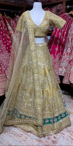 Glimmering Vegas gold embellished with floral in thread , sequins, zari & pearl work lehenga gives a royal appeal with similarly embroidered V neckline blouse and net dupatta. Sparkle, shimmer and all that glitz! Fabric: Silk Size: 38/M All preorders will be handled by a Nazranaa Bridal Consultant who will virtually discuss measurements and minor changes according to the client's specifications. Occasion: Wedding Ceremony or Reception. WASH CARE INSTRUCTIONS - Please Dry clean only when it is ap Wedding Embellished Art Silk Embroidered Fabric, Embellished Raw Silk Choli For Wedding, Wedding Choli In Embellished Raw Silk, Wedding Embellished Raw Silk Choli, Wedding Embellished Tissue Silk Choli, Bollywood Style Embellished Tissue Silk Lehenga, Embellished Raw Silk Sets For Wedding, Gold Embellished Lehenga In Tissue Silk, Embellished Art Silk Gown For Reception