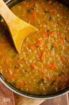 a wooden spoon in a pot filled with soup