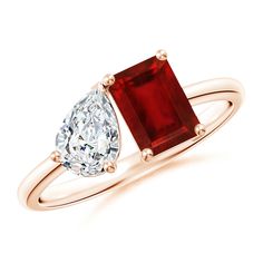 an engagement ring with a pear shaped diamond and a large red stone on the side