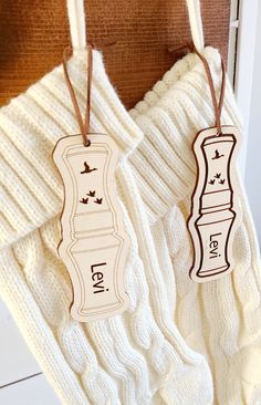 two tags hanging from the side of a white sweater