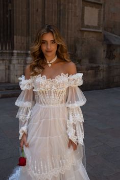 a woman in a white dress is walking down the street with her hand on her hip