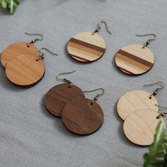 "These earrings are handmade using natural woods including walnut, maple, oak, cherry, Padauk, Purpleheart, mahogany, ash, elm, sycamore and more! For our signature striped design, individual pieces of wood are glued together then cut out in various shapes. Striped not your thing? We have our same design in solid walnut, cherry or maple. They are sprayed with a water-resistant finish. Ear wires are nickel-free, antique-plated brass. Handmade in Iowa. They are 1.5\" round with a drop length of ab Handmade Wooden Earrings For Everyday, Handmade Wooden Earrings For Everyday Wear, Everyday Handmade Wooden Earrings, Natural Wood Jewelry With Natural Variations, Handmade Wooden Jewelry, Solid Walnut, Napkin Holder, Color Blending, Wooden Jewelry