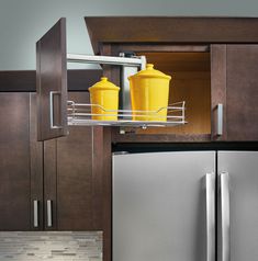 two yellow containers are sitting on the pull out shelf in front of a stainless steel refrigerator