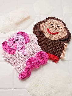 two crocheted items are sitting on a white tile floor, one is pink and the other is brown