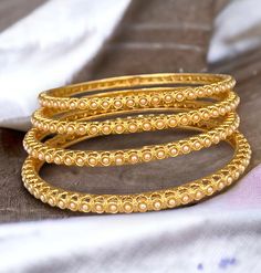 Indian gold pearl bangle set of 4. This beautiful gold finish bangles are made up of brass with embedded pearl details. Add this bangles to your chuda or wear it alone to get minimalistic look for any occasion.   All orders Ship same day if placed before 4:00 PM EST  Create beautiful memory for any occasion with elegant jewelry for your loved ones We will be happy to navigate you through the process so if you have any questions regarding our product before placing an order reach out to us and we Elegant Stackable Bangle For Festive Occasions, Elegant Stackable Bangle For Festivals, Gold Pearl Bracelet With Intricate Design For Wedding, Elegant Bangle For Wedding And Diwali, Elegant Festive Stackable Jewelry, Elegant Wedding Bangle For Diwali, Gold Plated Round Bangle For Wedding, Yellow Gold Bangle Pearl Bracelet For Wedding, Yellow Gold Pearl Bangle Bracelet For Wedding